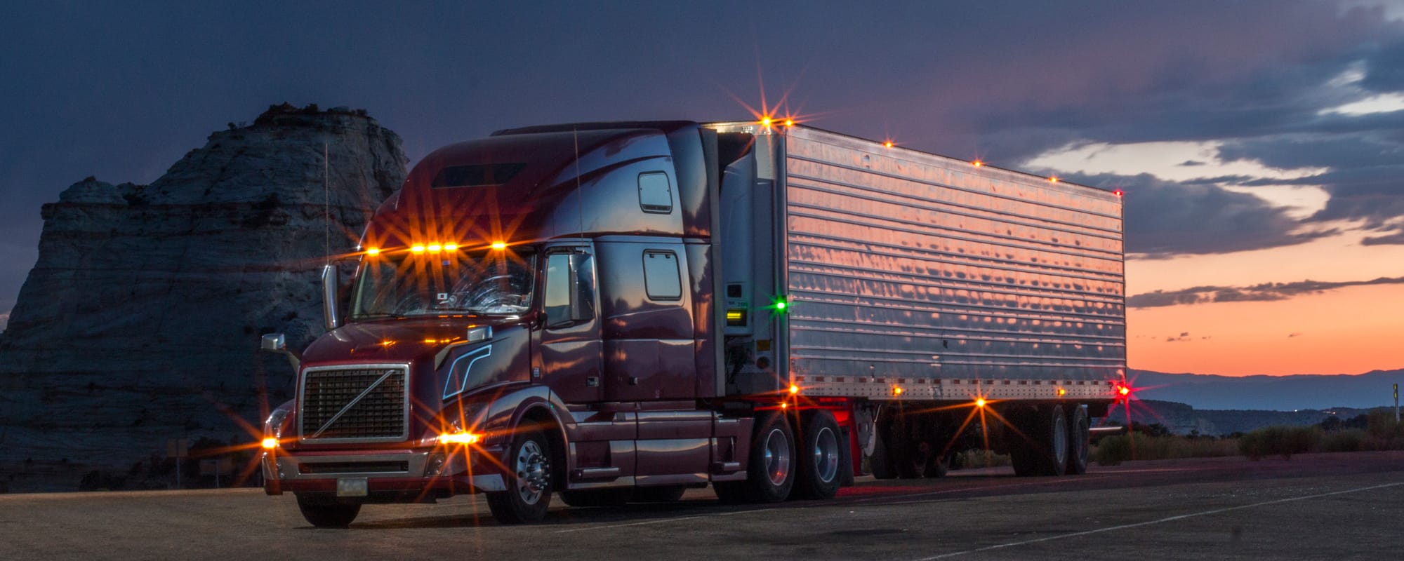 Image of tractor trailer parked with lights on